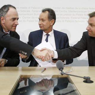 De gauche à droite, Christophe Darbellay, Philipp Müller et Toni Brunner concluent leur conférence de presse commune sur une poignée de mains, ce vendredi 27 mars 2015 à Berne. [Keystone - Peter Klaunzer]