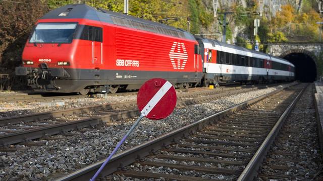 Un train passe à côté d'un panneau indiquant que la voie est fermée devant l'entrée du tunnel de St-Maurice. [Jean-Christophe Bott]