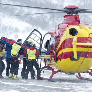 Un hélicoptère chargeant un blessé ce samedi 21 février 2015 au Grand Saint Bernard. [Maxime Schmid]