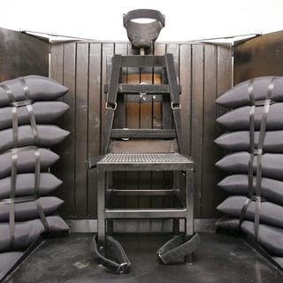 La chaise utilisée par le peloton d'exécution à la prison d'Etat de Draper, dans l'Utah. Quatre trous de balles sont visibles dans le panneau de bois. [POOL New]