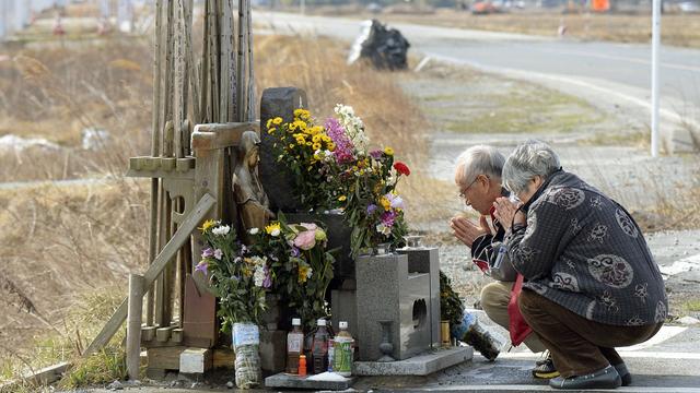 Un couple prie pour les victimes du tsunami, ce mercredi 11 mars 2015. [Kyodo News]