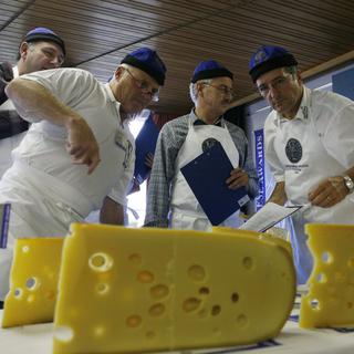 Des membres du jury des Swiss Cheese Awards notent un Emmental dûment troué. [Photopress/Yoshiko Kusano]