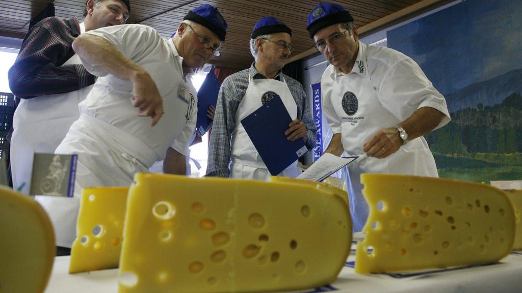 Des membres du jury des Swiss Cheese Awards notent un Emmental dûment troué. [Photopress/Yoshiko Kusano]