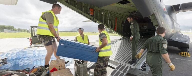 Des soldats chargent des vivres à bord d'un avion de l'armée française à destination du Vanuatu. [AFP Photo - Fred Payet]