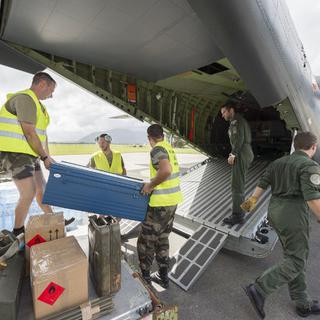 Des soldats chargent des vivres à bord d'un avion de l'armée française à destination du Vanuatu. [AFP Photo - Fred Payet]