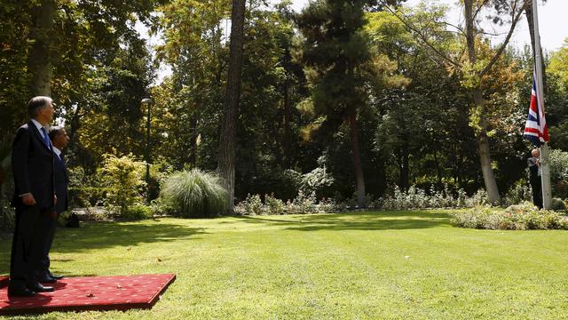 Le ministre des Affaires étrangères britanniques, Philip Hammond, regarde l'Union Jack s'élever dans les jardins de l'ambassade à Téhéran. [Darren Staples]