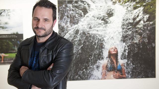 Christian Lutz devant l'une de ses photographies, au Musée de l'Elysée. [Keystone - Sandro Campardo]