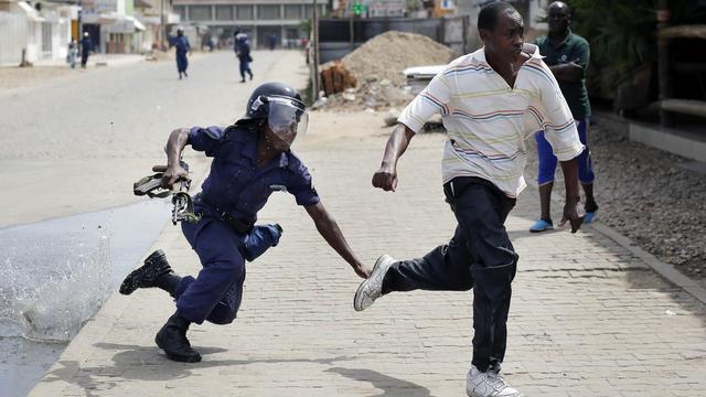 Un policier anti-émeutes aux trousses d'un manifestant, ce lundi 4 mai 2015 à Bujumbura. [AP Photo/Jerome Delay]