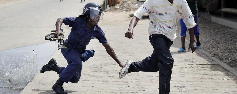 Un policier anti-émeutes aux trousses d'un manifestant, ce lundi 4 mai 2015 à Bujumbura. [AP Photo/Jerome Delay]