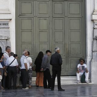Des personnes faisaient la queue lundi devant une banque en Grèce. [Keystone/EPA/YANNIS]