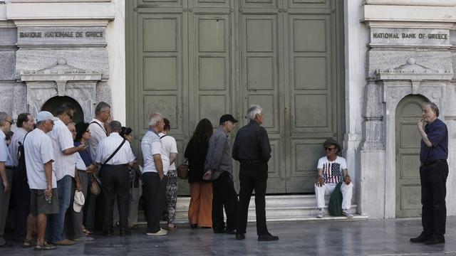 Des personnes faisaient la queue lundi devant une banque en Grèce. [Keystone/EPA/YANNIS]