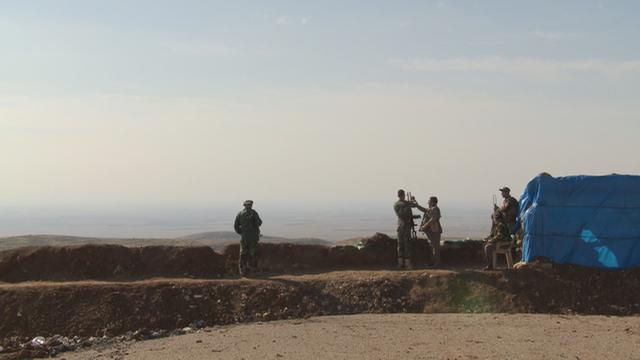 Des Peshmerga scrutant l'horizon pour protéger leur frontière des djihadistes de l'EI, dans la région de Mossoul.