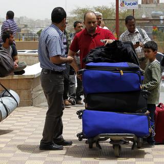 A l'aéroport de Sanaa, au Yémen, des centaines d'employés étrangers sont évacués suite aux intenses bombardements survenus les jours précédents. [Yahya Arhab - Keystone]