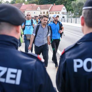 Un policier autrichien et son collègue hongrois à la frontière entre leurs deux pays. [AFP - Jure Makovec]
