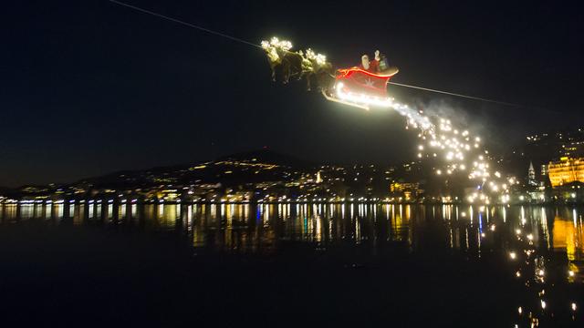 Le Père Noël en plein vol dans son traîneau salue la foule du marché de Noël de Montreux, le 23 décembre 2014.