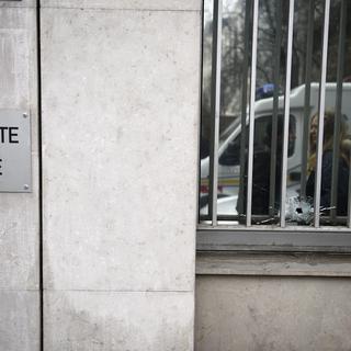 Un impact de balle dans une vitre du bâtiment de Charlie Hebdo. [AFP - Martin Bureau]
