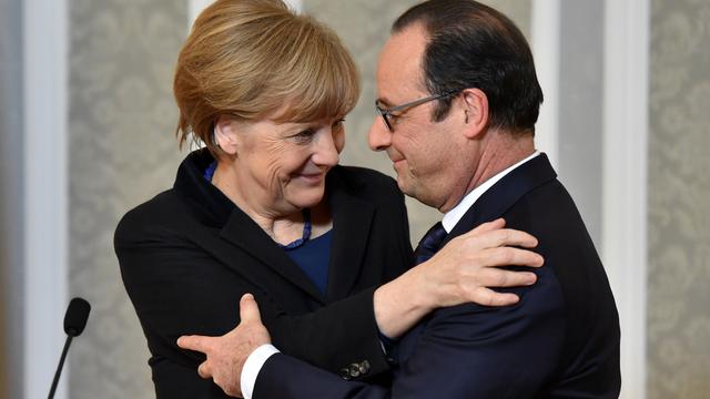 Angela Merkel et François Hollande se congratulent à l'issue de leur marathon diplomatique à Minsk. [Pool/AP/Keystone - Kirill Kudryavtsev]