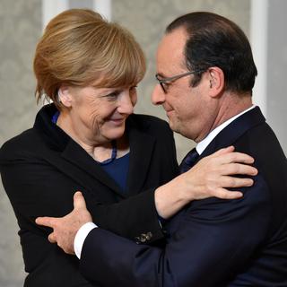 Angela Merkel et François Hollande se congratulent à l'issue de leur marathon diplomatique à Minsk. [Pool/AP/Keystone - Kirill Kudryavtsev]
