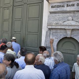 Retraités venus recevoir leur pension lundi matin au siège de la banque nationale à Athènes. [AP/Keystone - Petros Giannakouris]