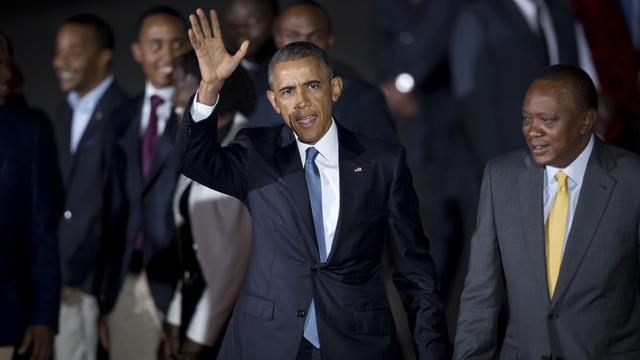 Barack Obama salue la foule après avoir été accueilli par le président kényan, Uhuru Kenyatta (à droite).