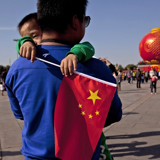 epa02942502 A picture made available on 30 September 2011 of a Chinese boy carrying the national flag while visiting Tiananmen Square in Beijing, China, on 29 September 2011, where a giant red lantern is on display. China will observe the start of the 'National Day' holiday on 01 October, marking the 62nd anniversary of their independence. EPA/HOW HWEE YOUNG [EPA/Keystone - How Hwee Young]