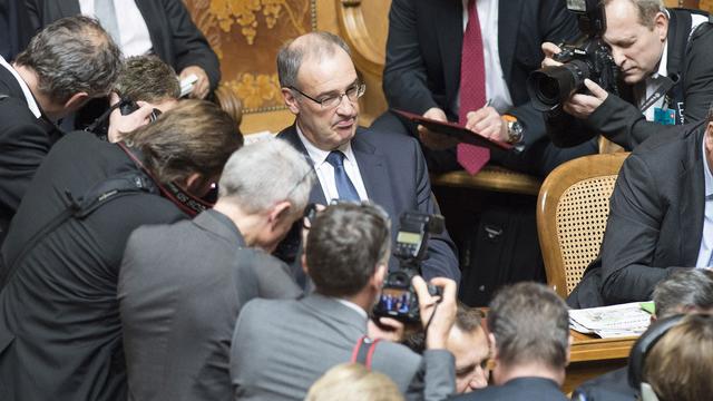 Guy Parmelin assailli par les photographes entre deux tours de l'élection. [Pool/Keystone - Peter Schneider]