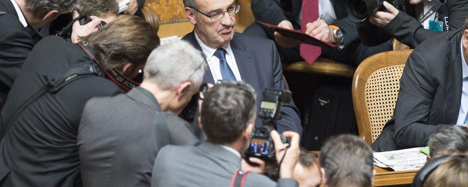 Guy Parmelin assailli par les photographes entre deux tours de l'élection. [Pool/Keystone - Peter Schneider]