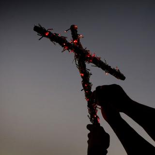 Des chrétiens d'Iraq fuyant les violences à Mosoul décorent une croix. [Safin Hamed]