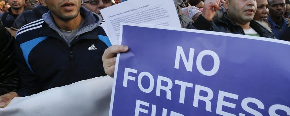 Des migrants manifestent à Bruxelles. [key - EPA/Olivier Hoslet]