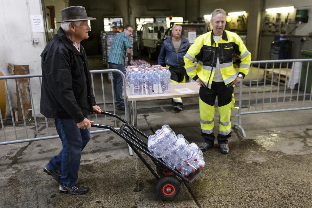 Les autorités communales ont distribué gratuitement des bouteilles d'eau à la population. [Keystone - JEAN-CHRISTOPHE BOTT]
