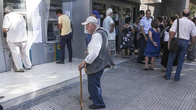 Des citoyens grecs attendent pour retirer de l'argent au bancomat à Athènes, le 9 juillet. [Anadolu Agency - Ayhan Mehmet]