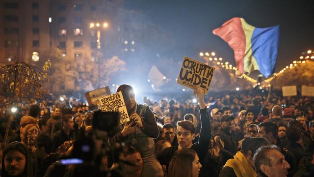 "La corruption tue" ou "l'Eglise lave les cerveaux et blanchit l'argent public", peut-on lire sur les panneaux brandis par les manifestants à Bucarest, ce 4 novembre 2015. [AP Photo/Vadim Ghirda)]