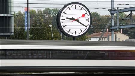 Un train passe devant l'horloge géante installée devant le nouveau quartier général des CFF à Berne.