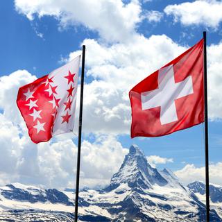 Le drapeau valaisan et le drapeau suisse avec le Cervin en arrière-plan. [Fotolia - mlehmann78]