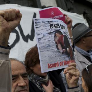 Un manifestant qui soutient les migrants brandit une pancarte avec la photo du petit Aylan à Paris le 5 septembre 2015. [CITIZENSIDE/AFP - Patrice Pierrot]