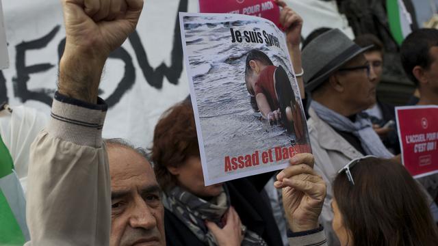 Un manifestant qui soutient les migrants brandit une pancarte avec la photo du petit Aylan à Paris le 5 septembre 2015. [CITIZENSIDE/AFP - Patrice Pierrot]