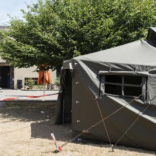 Les tentes militaires installées devant un centres d'accueil déjà existant. [Ennio Leanza]