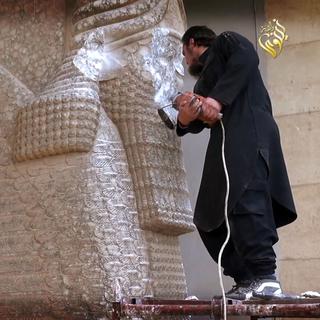 Militant de l'Etat Islamique détruisant une statue assyrienne à Ninive, au nord de l'Iraq. [AFP PHOTO / HO / Media Office of the Nineveh branch]
