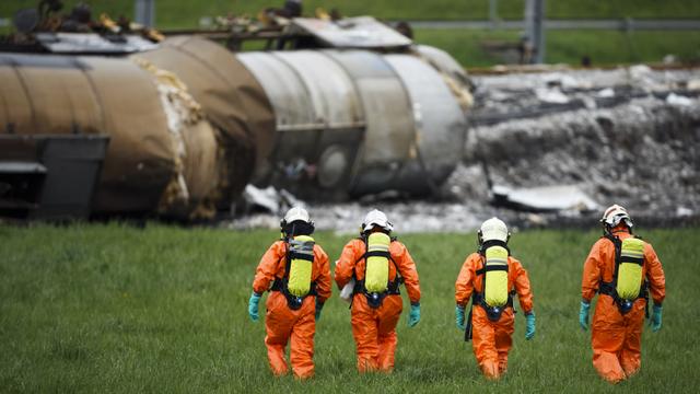 Les pompiers et les employés spécialisés sur place procèdent actuellement aux travaux préparatoires pour le relevage des autres wagons. [Valentin Flauraud]