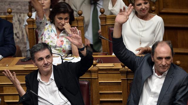 Les ministres grecs des Finances et de l'Economie votent sur la procédure lors des débats à la Vouli. [AFP PHOTO - Louisa Goulimaki]