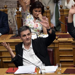 Les ministres grecs des Finances et de l'Economie votent sur la procédure lors des débats à la Vouli. [AFP PHOTO - Louisa Goulimaki]