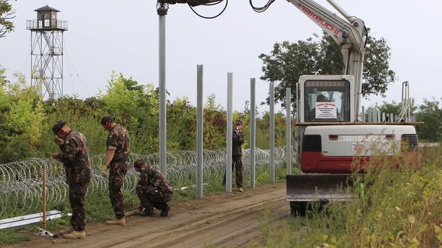 Des soldats hongrois installent des barbelés à la frontière croato-hongroise. [Reuters - Bernadett Szabo]