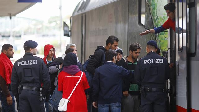 Des policiers autrichiens escortant des migrants dans un train à destination de l'Allemagne.