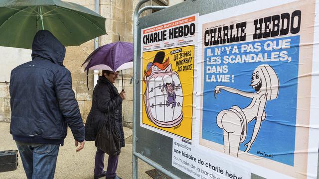 Des visiteurs à l'entrée de l'exposition rétrospective sur Charlie Hebdo, mise en place par le Festival international de la bande dessinée d'Angoulême. [AFP PHOTO - PIERRE DUFFOUR]