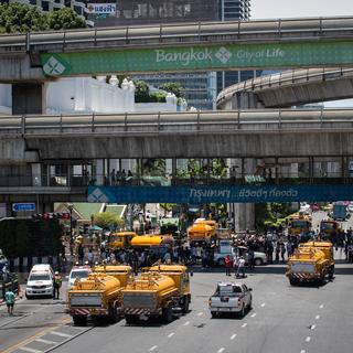 A Bangkok, des employés nettoient les débris de l'explosion survenue la veille près d'un temple touristique. [Guillaume Payen / Anadolu Agency]