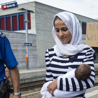 "Les réfugiés sont les bienvenus ici", affirme la pancarte d'un manifestant à Buchs (SG), mardi 1er septembre. [Dominic Steinmann]