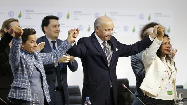 Le ministre français des Affaires étrangères et président de la COP21, Laurent Fabius, célèbre l'adoption de l'accord. [Reuters - Stephane Mahe]