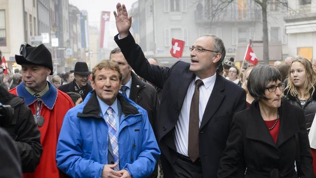 Le couple Parmelin accuelli par les Nyonnais et leur syndic Daniel Rossellat (en bleu). [KEYSTONE - JEAN-CHRISTOPHE BOTT]