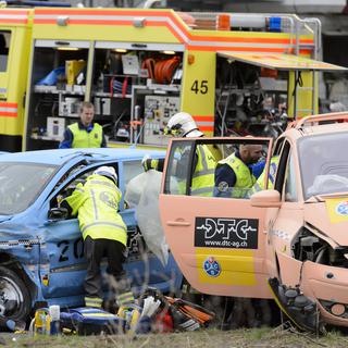 Des secouristes s'affairent autour de blessés fictifs après un crash test au Mont-sur-Lausanne. [Laurent Gillieron]