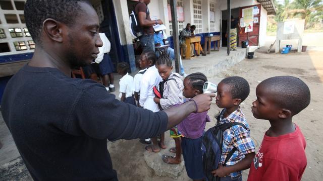 La température est mesurée auprès d'élèves d'une école de Monrovia, au Libéria. [AP/Keystone - Ahmed Jallanzo]